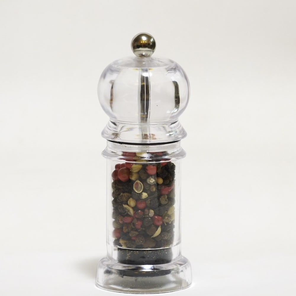 Wild red peppercorn in a glass grinder