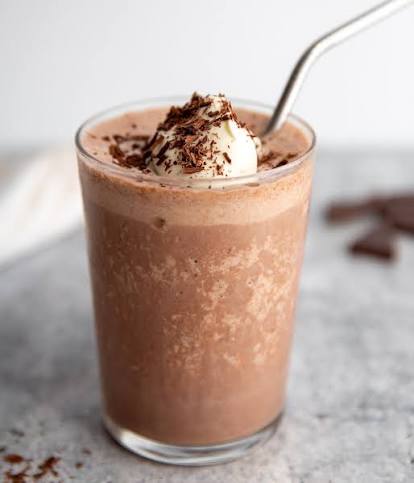 Chilled cocoa milk shake topped with cream and shaved chocolate