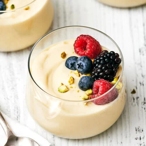 Vanilla custard cups layered with raspberries, blueberries, and blackberries
